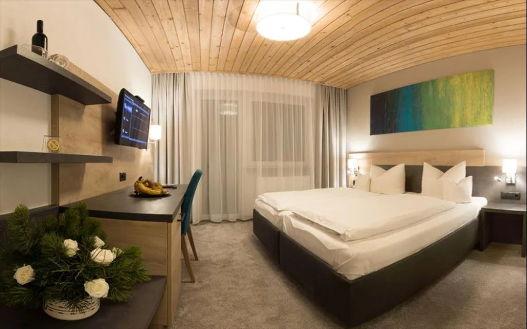 Camera confortevole con letto matrimoniale, scrivania, TV e decorazioni floreali