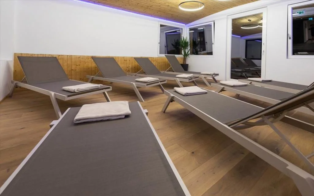 Zona relax della spa con lettini e pavimento in legno