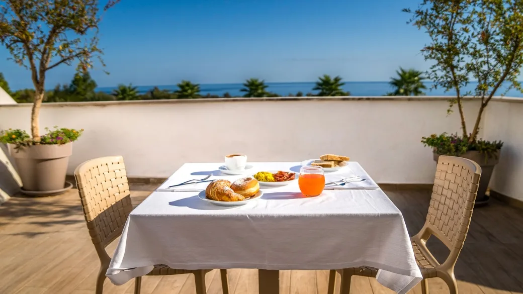 Colazione servita su tavolo in terrazza con vista mare