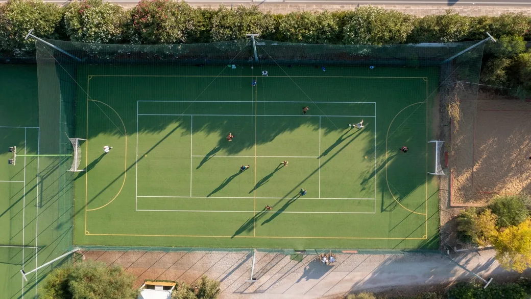 Vista aerea del campo sportivo in erba sintetica con persone che giocano