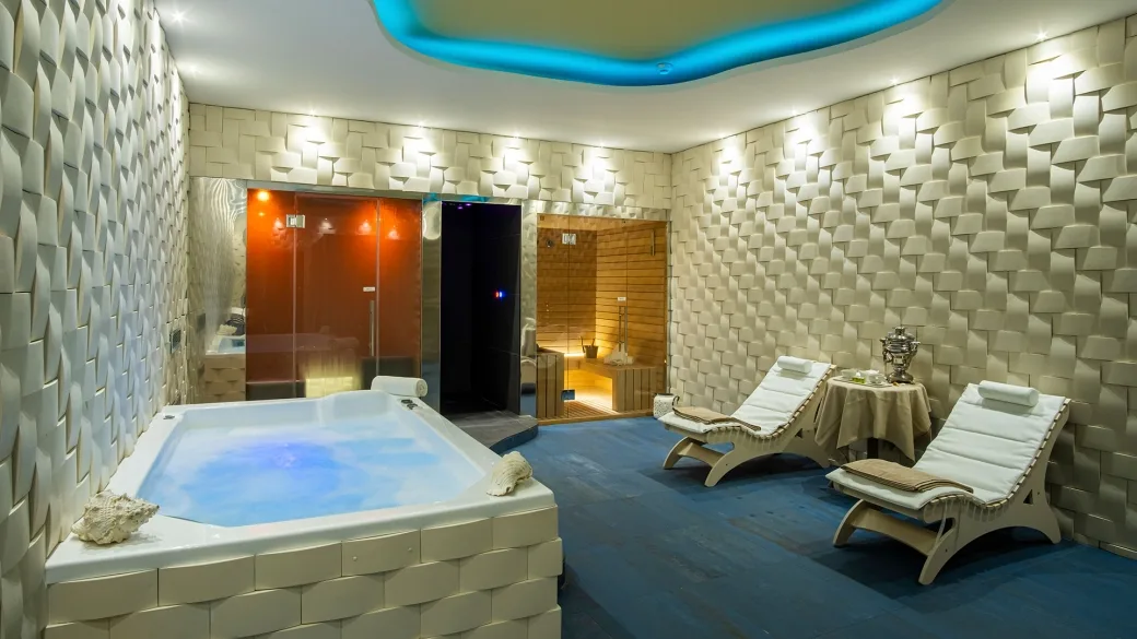Area benessere con vasca idromassaggio, sauna e lettini relax