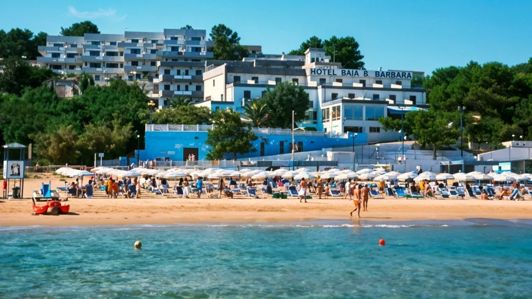 Vista dal mare dell'Hotel Baia & Barbara con spiaggia affollata, ombrelloni e bagnanti