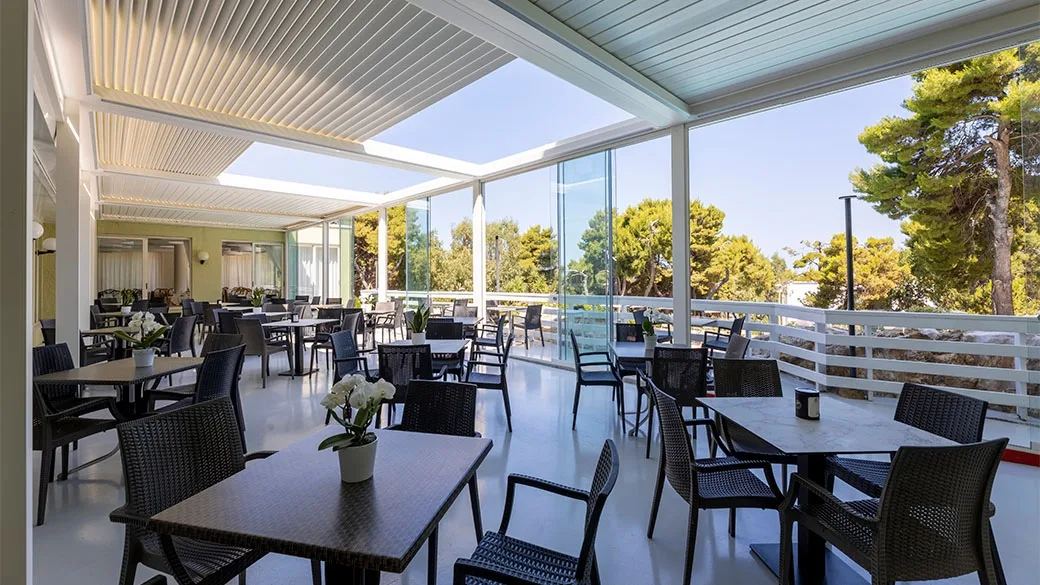 Terrazza coperta con tavoli e sedie e vista sul giardino