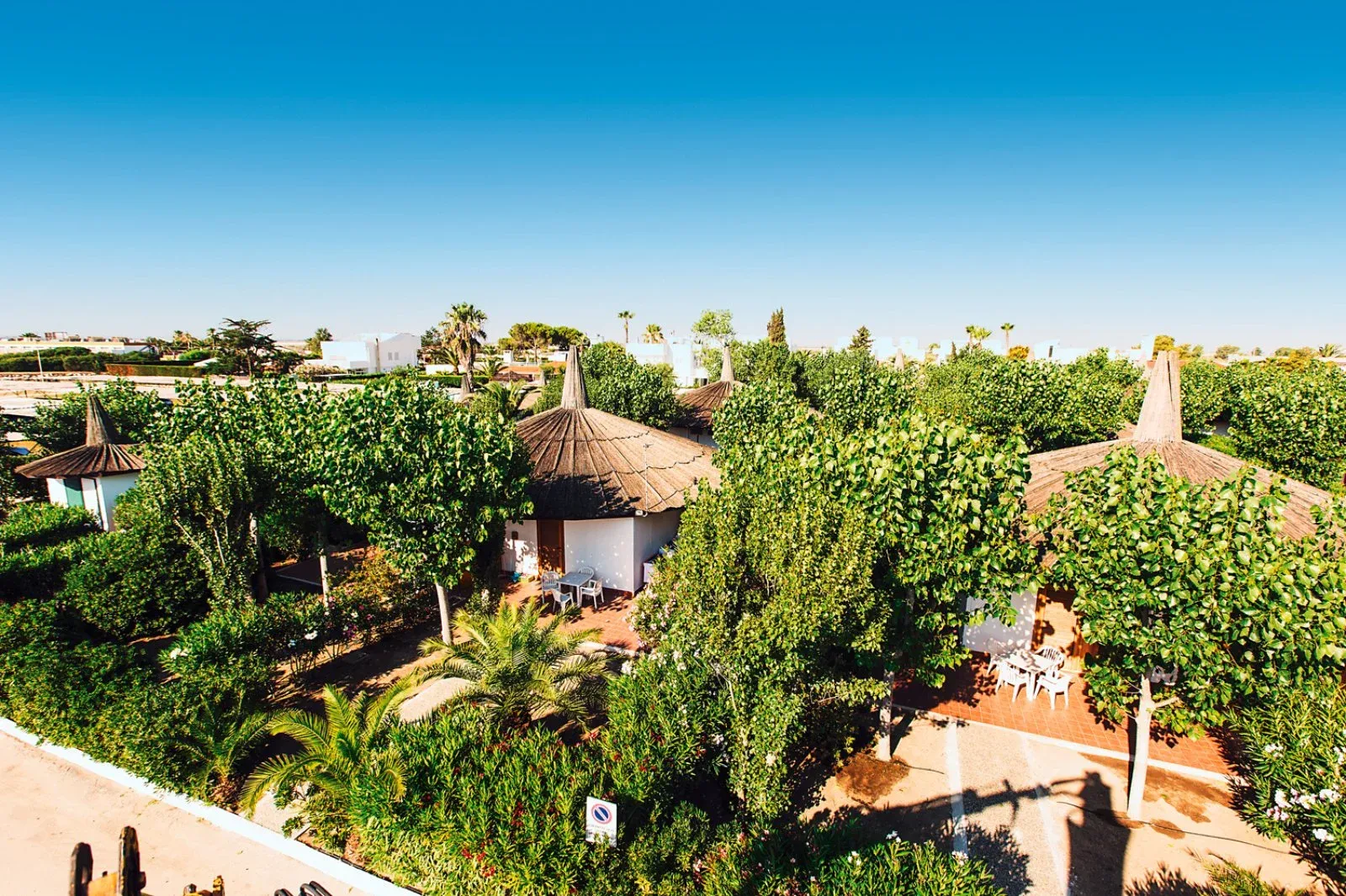 Bungalow con tetto in paglia immersi nel giardino verde del resort