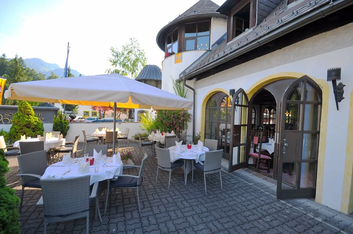 Terrazza esterna del ristorante con tavoli apparecchiati e ombrelloni