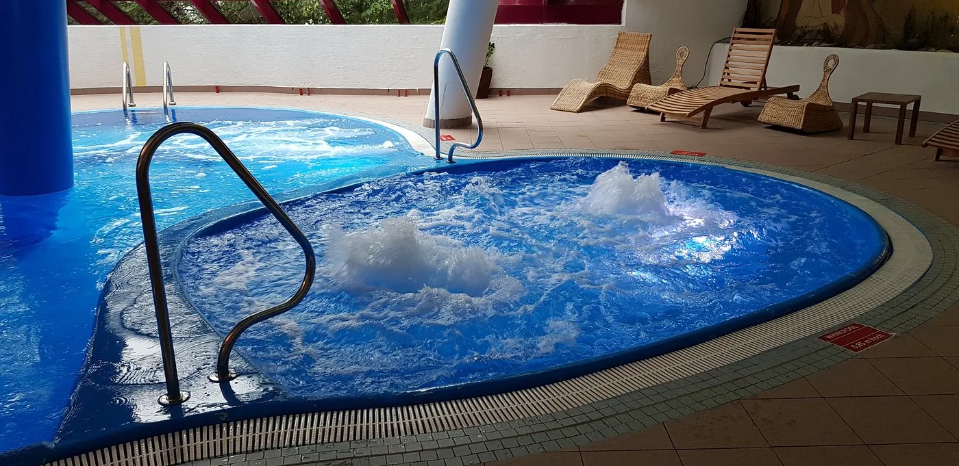 Vasca idromassaggio con getti d'acqua e lettini in vimini