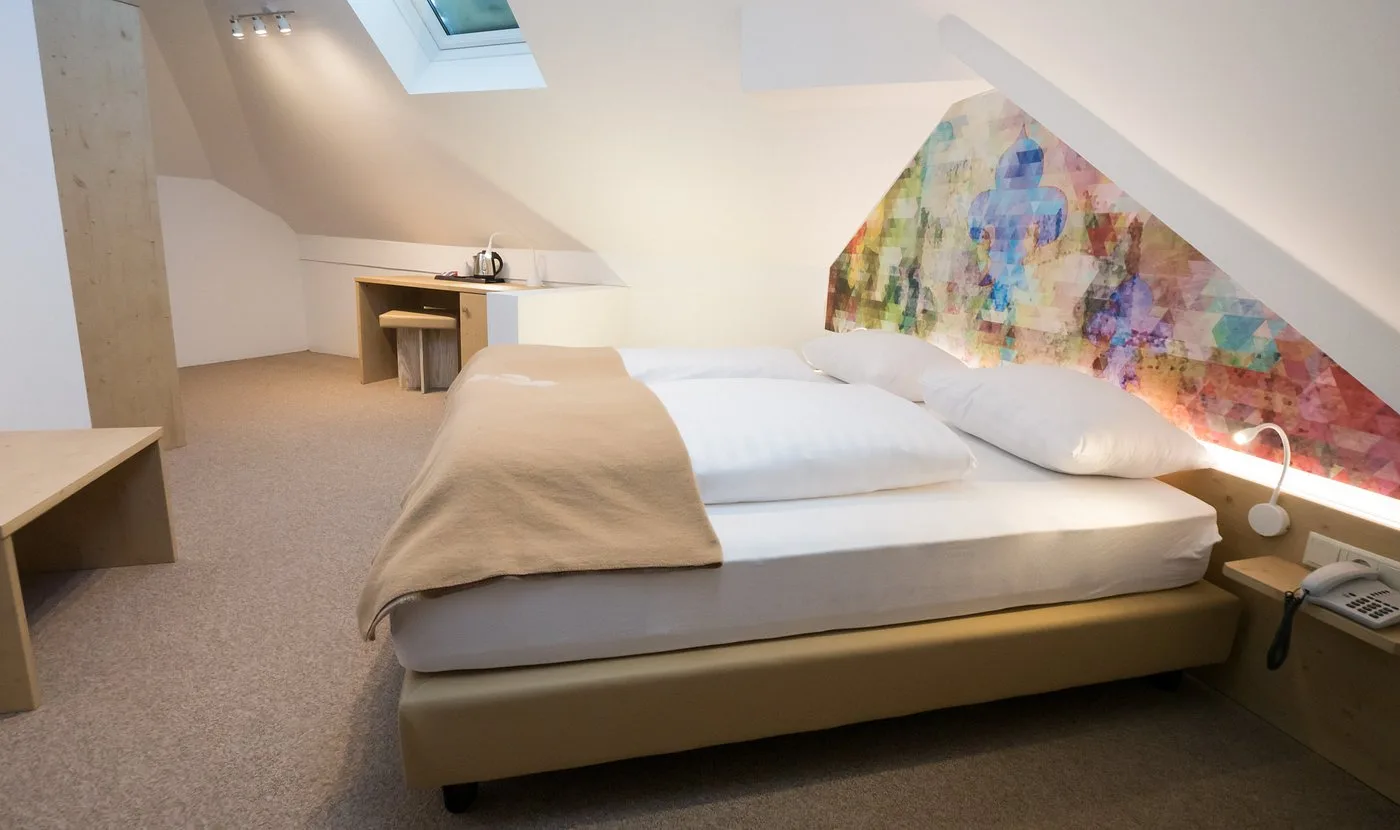 Camera mansardata con letto matrimoniale e lucernario