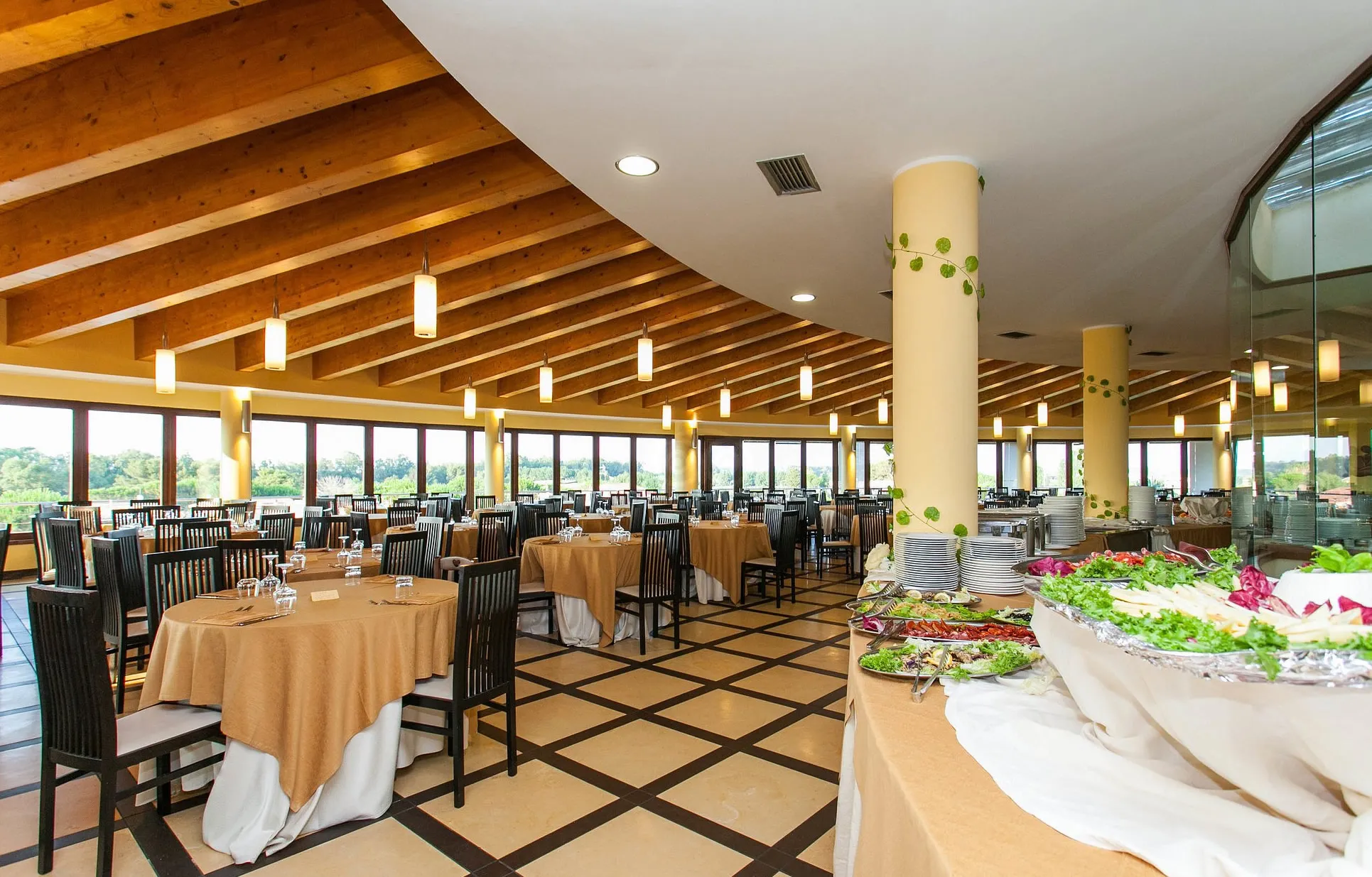 Ristorante con buffet di antipasti, tavoli apparecchiati e ampie vetrate panoramiche