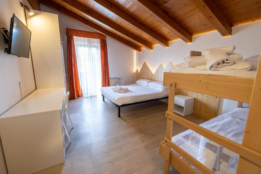 Camera con letto matrimoniale, letto a castello, soffitto in legno e TV a parete