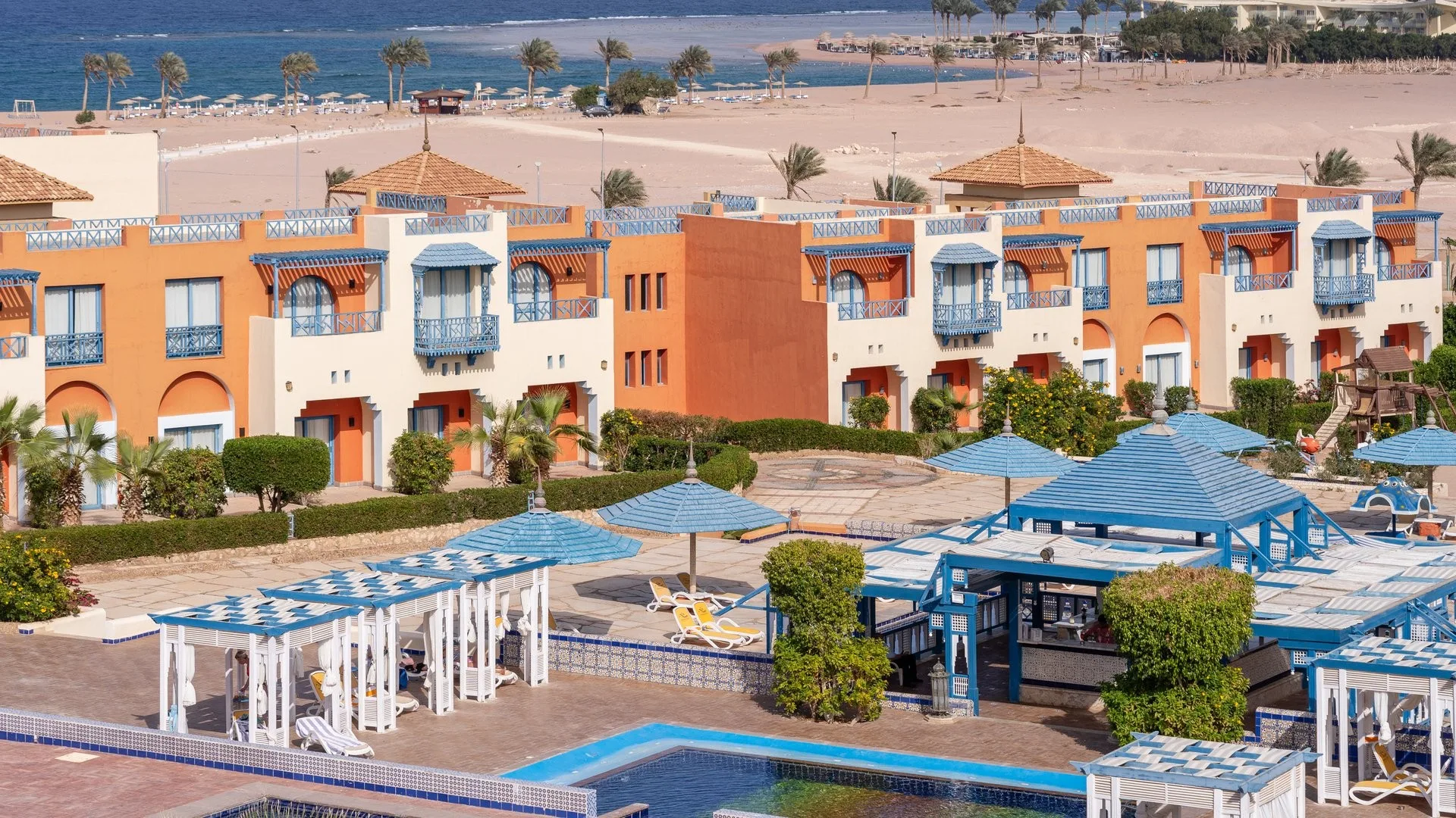Edifici del resort in stile mediterraneo con balconi blu e vista sulla spiaggia e sul mare