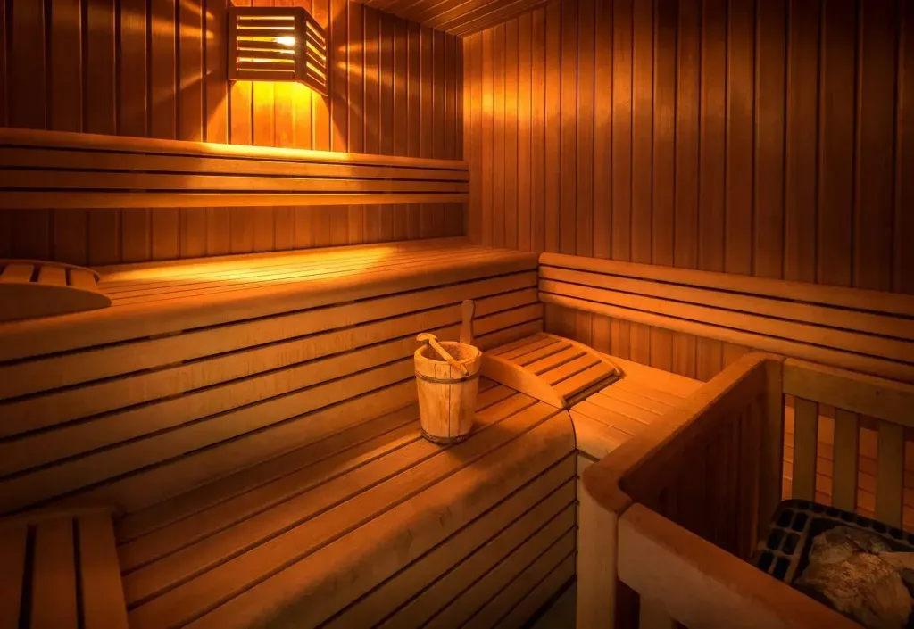 Sauna finlandese in legno con secchiello e illuminazione soffusa