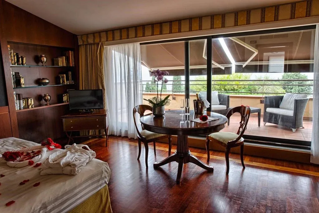 Suite con letto decorato con petali di rosa, tavolo da pranzo e terrazza panoramica