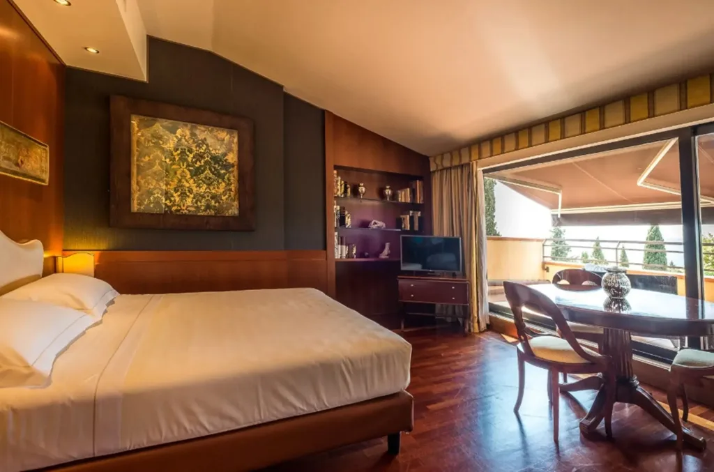 Suite con letto matrimoniale, tavolo da pranzo e terrazza affacciata sul verde
