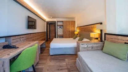 Camera con letto, divano e scrivania in stile rustico, con illuminazione calda.
