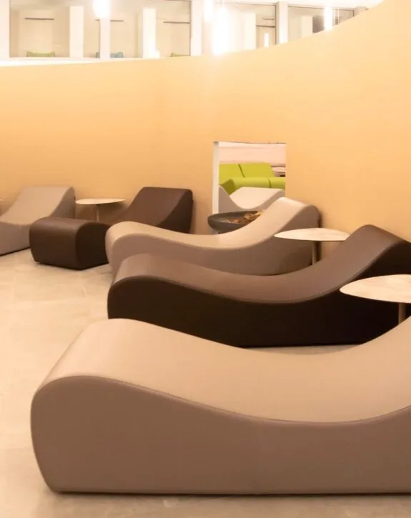 Sdraio moderne in bianco, nero e grigio con tavolini in marmo in un'area lounge.