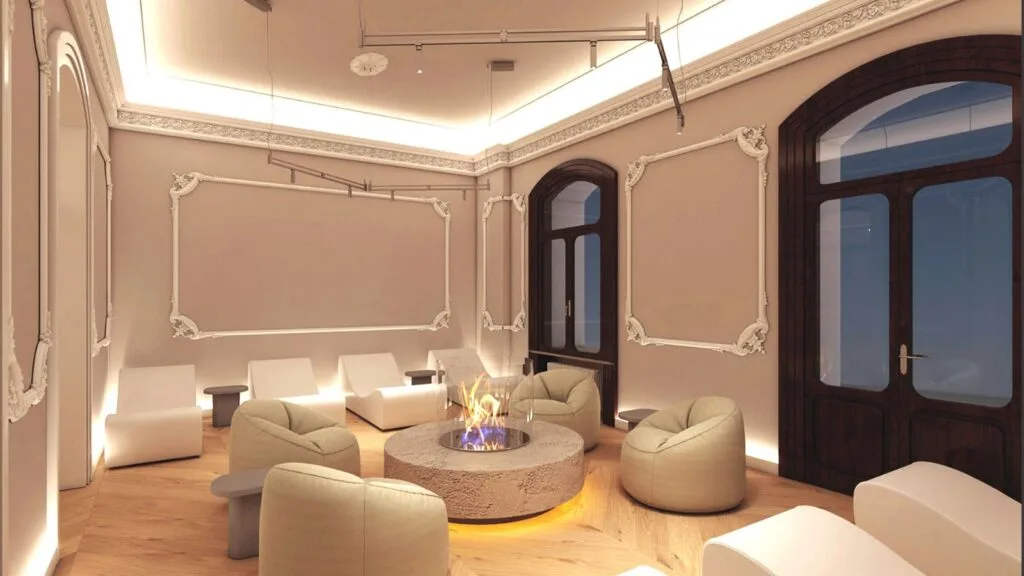 Salotto elegante con poltrone beige, caminetto moderno rotondo centrale e pareti decorate con stucchi bianchi.