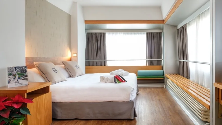Camera moderna con letto matrimoniale e ampia finestra con seduta