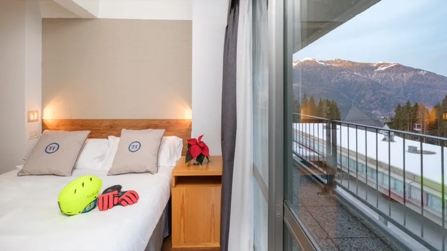 Camera con balcone e vista panoramica sulle montagne innevate