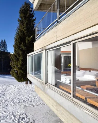 Dettaglio esterno della camera con ampie vetrate affacciate sulla neve
