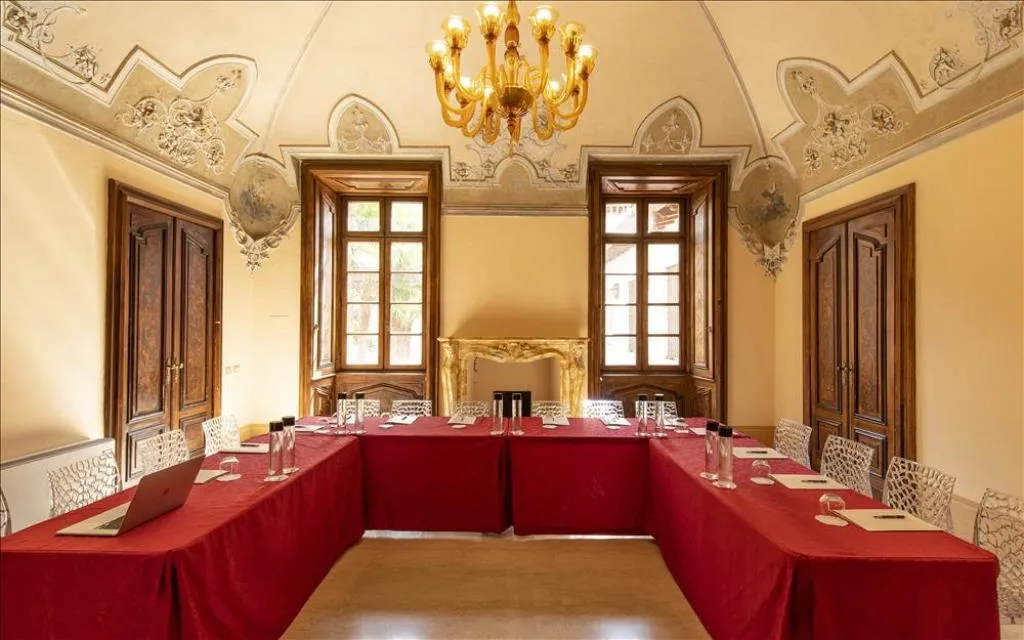 Sala riunioni con soffitto affrescato, tavolo a ferro di cavallo e camino dorato