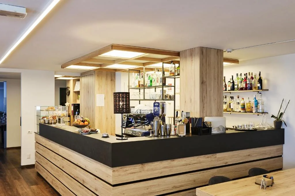 Bancone bar moderno in legno con macchina da caffè e bottiglie
