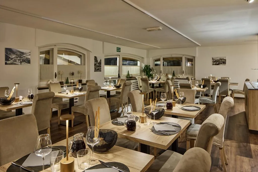 Sala ristorante con tavoli apparecchiati e illuminazione soffusa