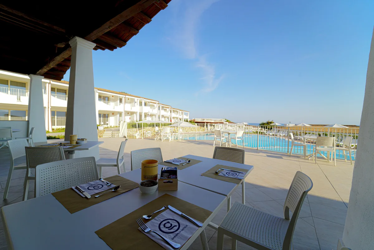 Terrazza del ristorante con tavoli e vista sulla piscina