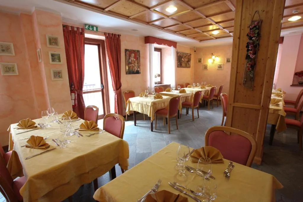 Sala ristorante con tavoli apparecchiati, tovaglie gialle e soffitto in legno