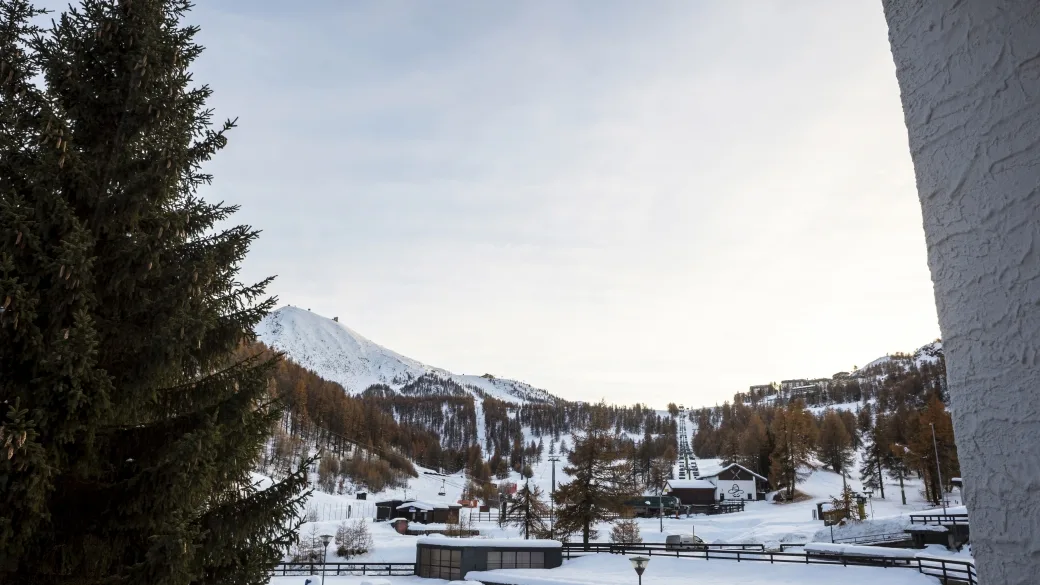 Paesaggio invernale innevato con montagne e piste da sci visto dall'hotel