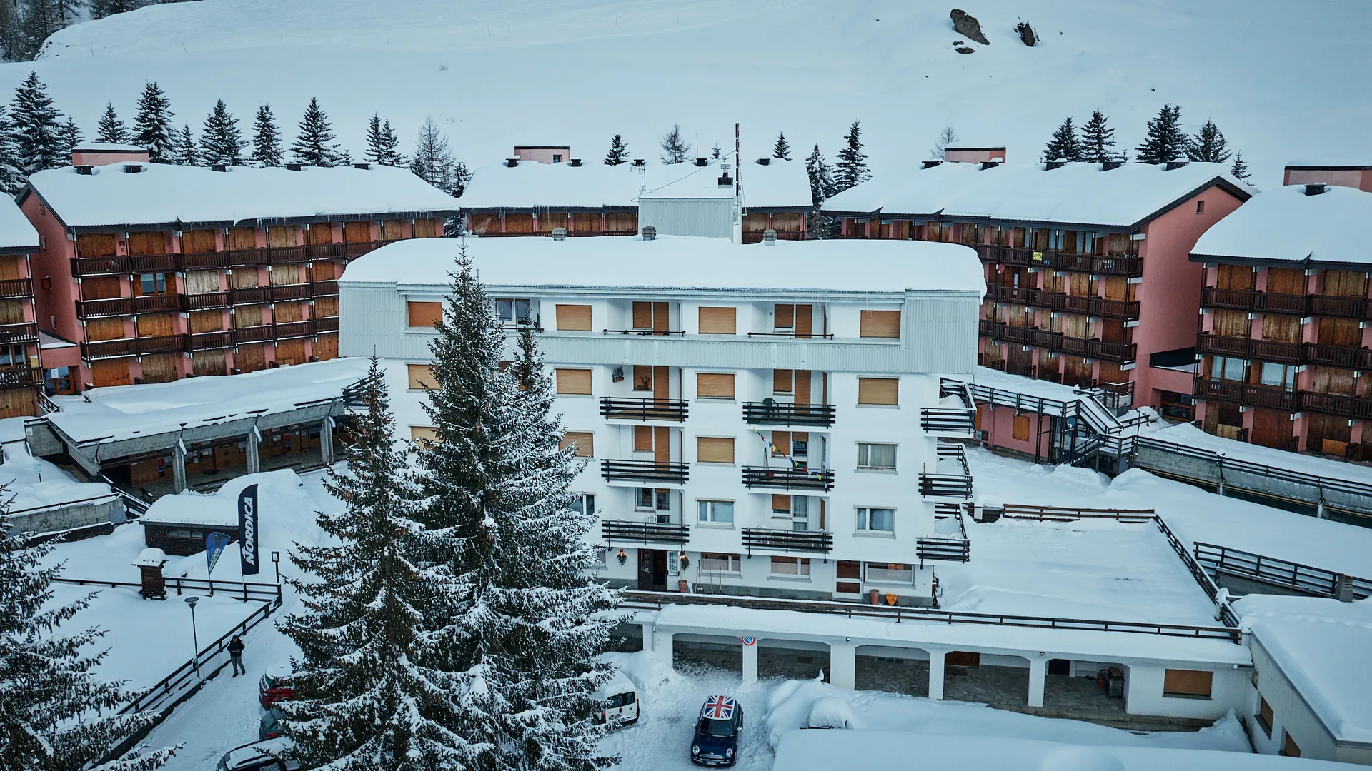 Veduta aerea dell'hotel innevato con abeti e edifici circostanti in inverno