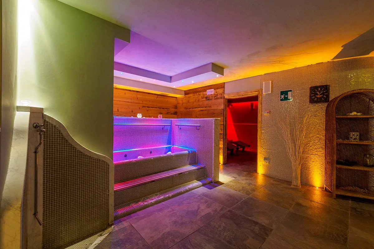 Area spa dell'hotel con vasca idromassaggio e illuminazione colorata
