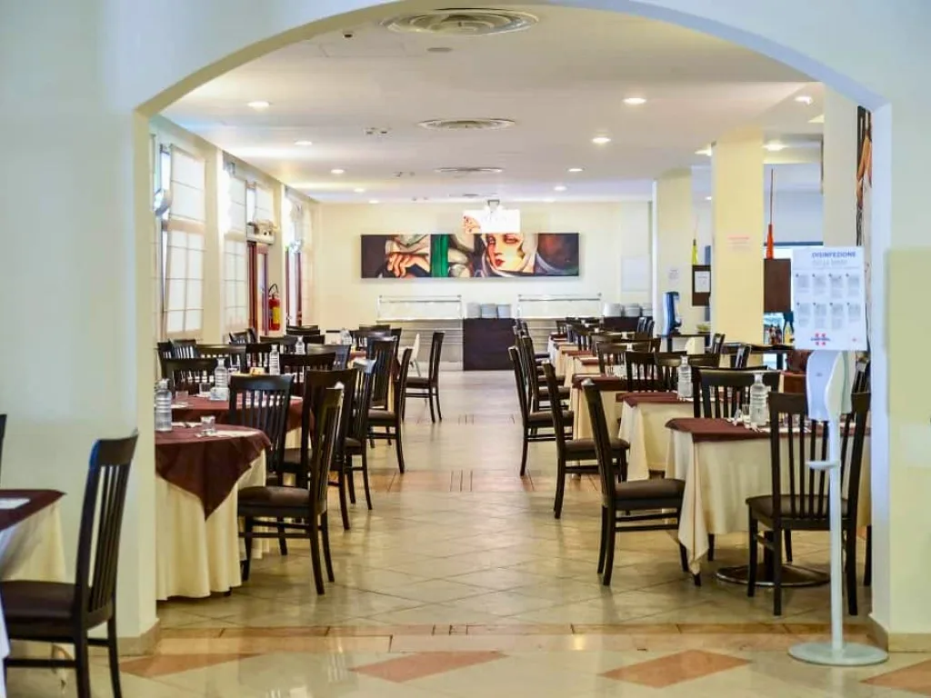 Sala da pranzo interna con tavoli e sedie eleganti