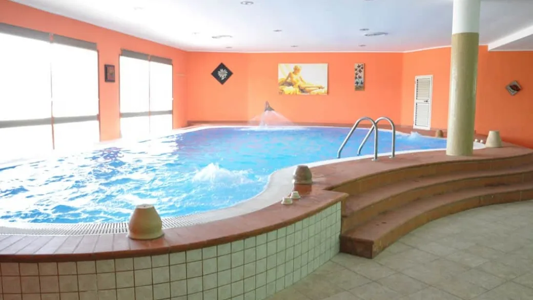 Piscina coperta interna con idromassaggio e pareti arancioni