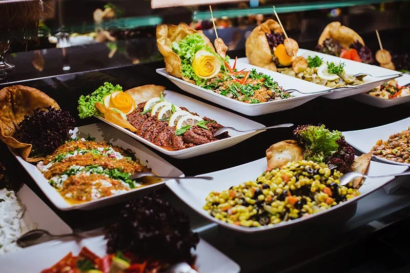 Buffet ricco di piatti caldi e insalate decorate esposti al ristorante