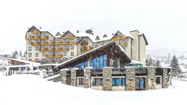 Esterno dell'hotel durante una nevicata con area benessere e vetrate panoramiche