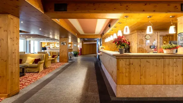 Hall dell'hotel con reception in legno, poltrone e illuminazione calda