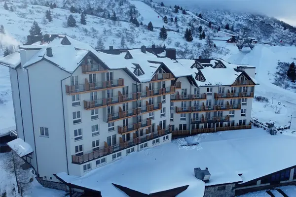 Vista aerea dell'hotel con tetti e balconi coperti di neve sulle piste da sci