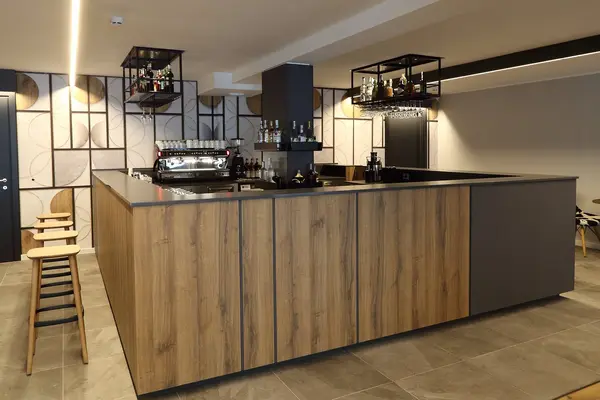 Bancone bar in legno con macchina da caffè e scaffali di bottiglie