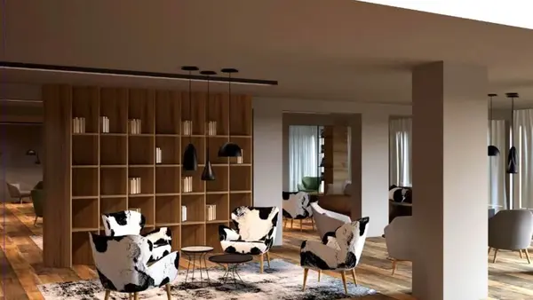 Zona relax con libreria in legno e poltrone fantasia mucca