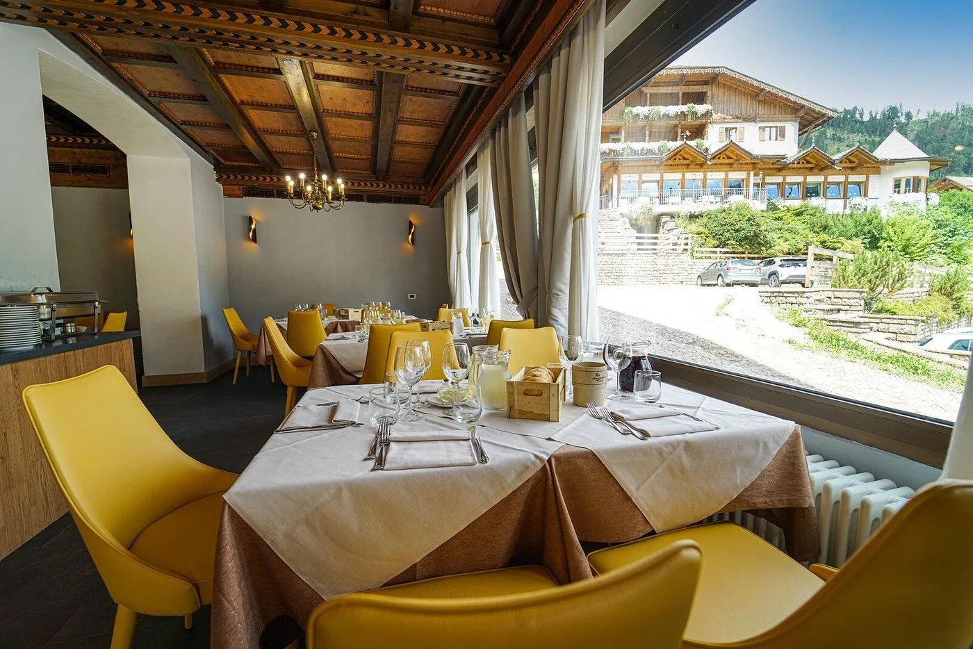 Sala ristorante con grande vetrata affacciata sul paesaggio alpino