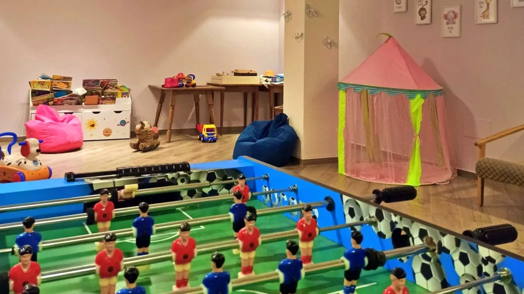 Sala giochi per bambini con calcio balilla, giocattoli e tenda da gioco