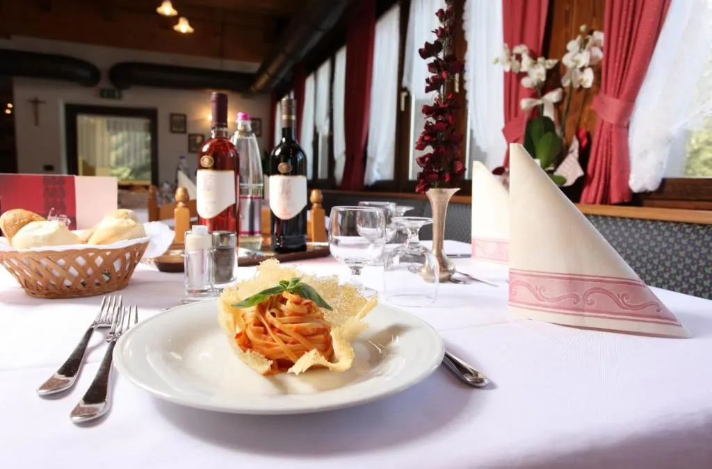 Piatto di tagliatelle con cialda di parmigiano servito su tavolo elegante del ristorante