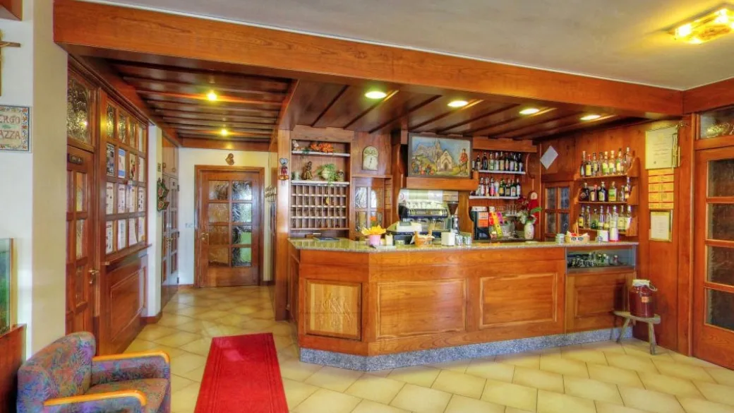 Reception e bar in legno con bottiglie e arredo tipico di montagna