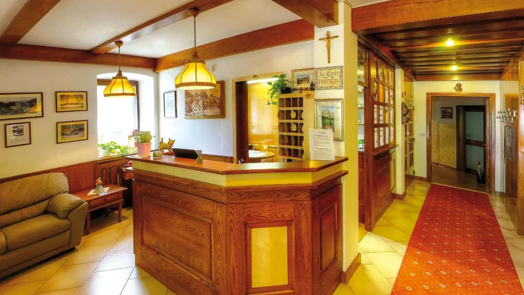 Reception in legno con divano e quadri alle pareti