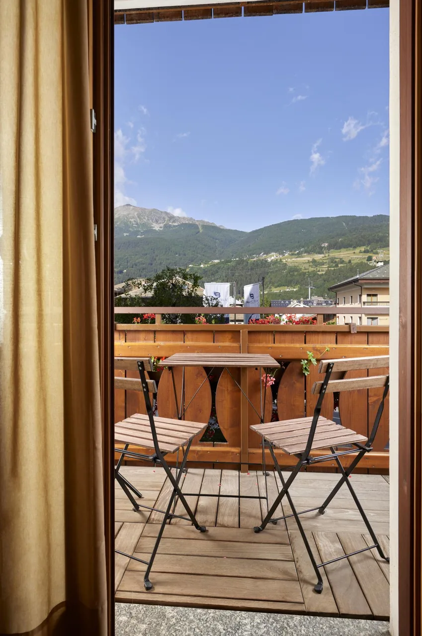 Vista dal balcone della camera con tavolino e panorama sulle montagne