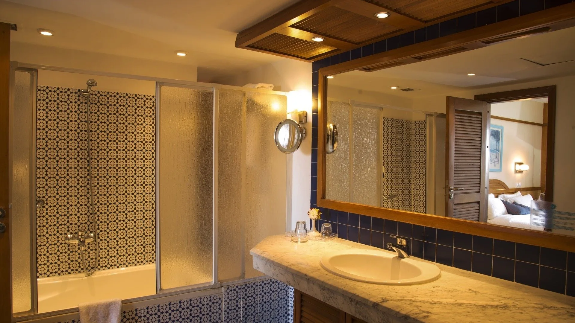 Bagno della camera con vasca, doccia, lavabo in marmo e ampio specchio