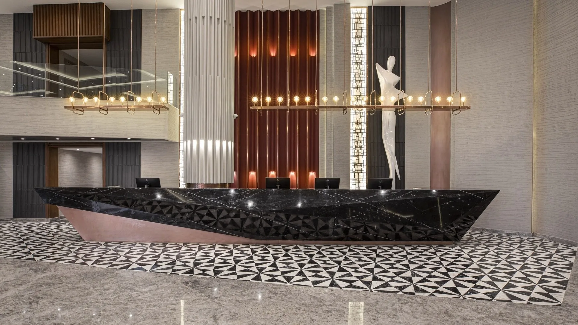 Reception elegante con bancone in marmo nero, scultura bianca e pavimento geometrico