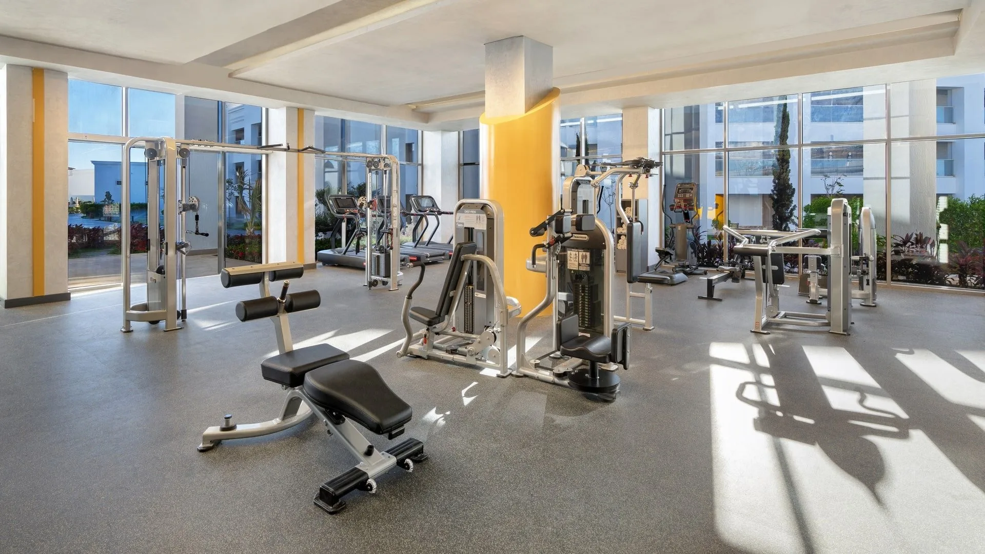 Sala fitness attrezzata con macchine per allenamento e ampie vetrate luminose