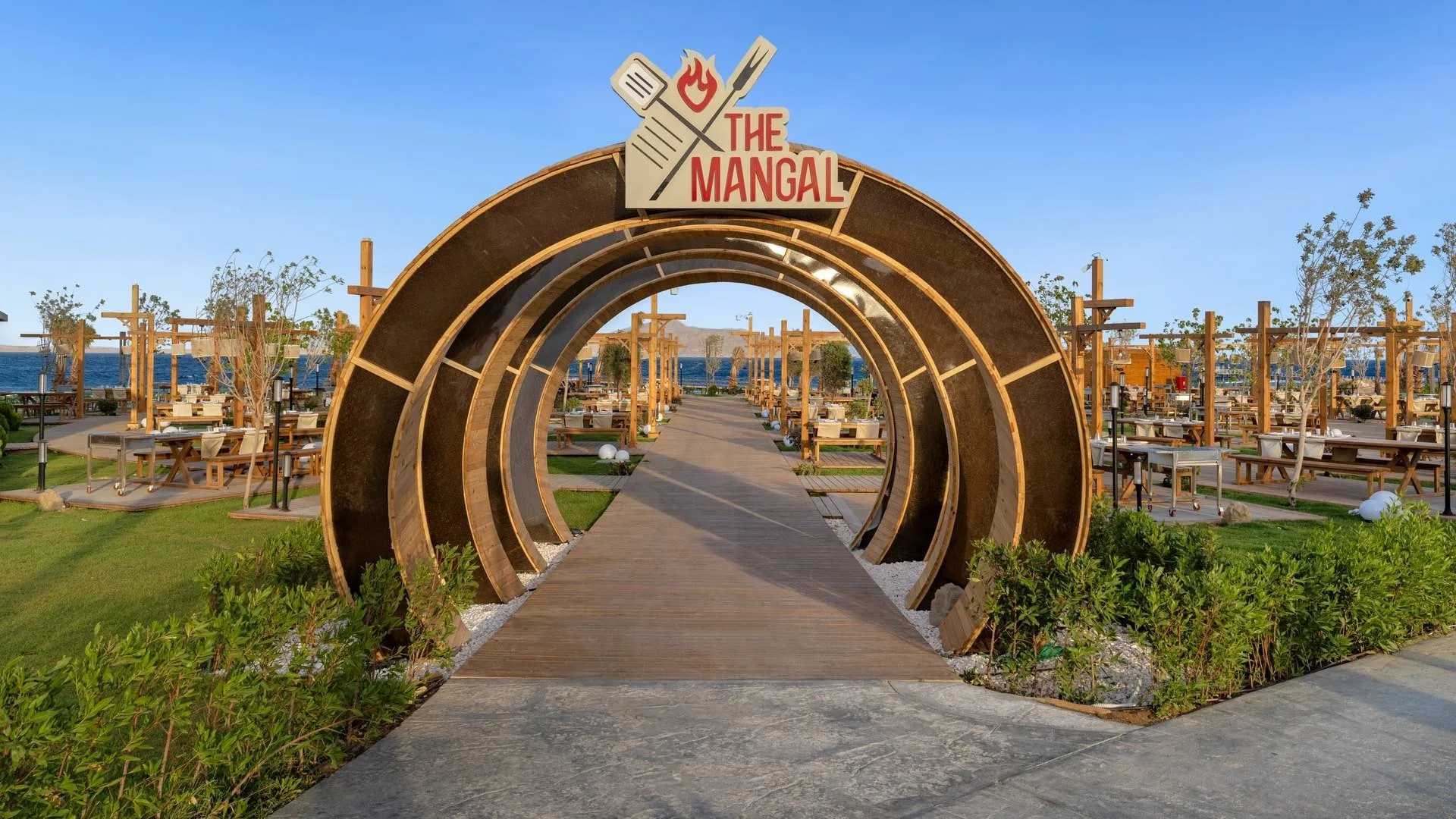 Ingresso ad arco in legno del ristorante grill The Mangal con vista sul mare