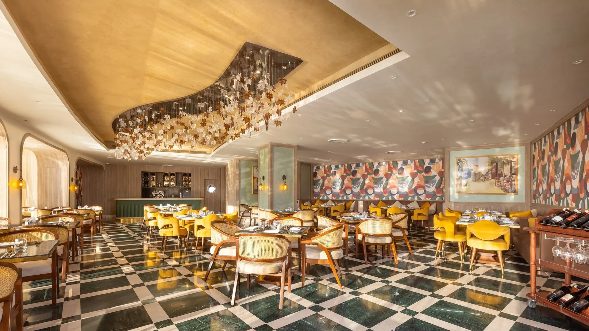 Ristorante di lusso con lampadario decorativo, sedie gialle e murales colorati